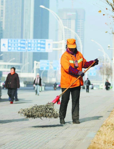图为余友珍在扫街。记者何晓刚 摄 图为余友珍在扫街。记者何晓刚 摄