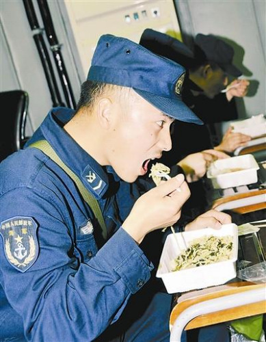 “青岛”舰上的官兵在战位上吃野战快餐。图片来源:解放军报 记者 米晋国摄 “青岛”舰上的官兵在战位上吃野战快餐。图片来源:解放军报 记者 米晋国摄