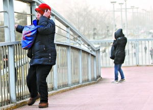 上午11时,在东单路口过街桥上,行人在大风中难以前行。本报记者 白继开摄 上午11时,在东单路口过街桥上,行人在大风中难以前行。本报记者 白继开摄