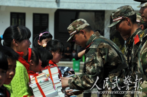赠送书籍。图片来源:人民武警报 赠送书籍。图片来源:人民武警报