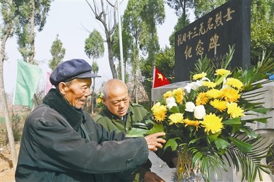 裴麦闹(左)和儿子裴献周整理烈士纪念碑前的花篮。 曾宪平摄 裴麦闹(左)和儿子裴献周整理烈士纪念碑前的花篮。 曾宪平摄
