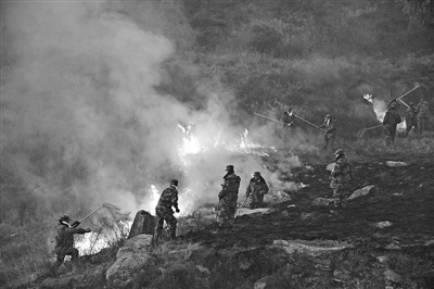 官兵们奋力扑救山火。 官兵们奋力扑救山火。