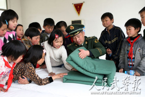 指导员李明教孩子们叠被子 指导员李明教孩子们叠被子