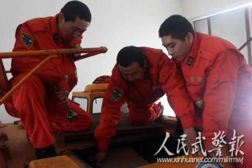 吴云(中)在教授战士维修灭火装甲车 吴云(中)在教授战士维修灭火装甲车