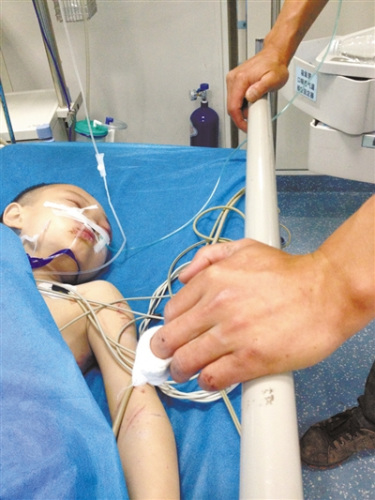 昨日,10岁的黄肖在医院接受治疗,父亲在一旁陪护。父亲手上的伤痕,都是手刨儿子时留下的。新京报记者 何光 摄 昨日,10岁的黄肖在医院接受治疗,父亲在一旁陪护。父亲手上的伤痕,都是手刨儿子时留下的。新京报记者 何光 摄