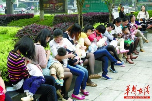 5月19日,在长沙市万家丽路人民东路口车站旁,40多位潮妈在大街上给宝宝喂奶,吸引了不少路人的注意。(读者供图) 5月19日,在长沙市万家丽路人民东路口车站旁,40多位潮妈在大街上给宝宝喂奶,吸引了不少路人的注意。(读者供图)