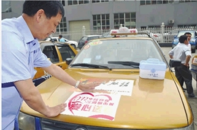 6月6日,长沙市北京御园小区,爱心送考的的哥的姐们在贴送考车贴。 实习记者 唐俊 摄 6月6日,长沙市北京御园小区,爱心送考的的哥的姐们在贴送考车贴。 实习记者 唐俊 摄