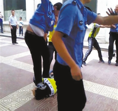 “延安城管暴力执法”视频中,刘国峰被一名城管队员跳起来踩中头部,致其昏迷。图片来源西部网 “延安城管暴力执法”视频中,刘国峰被一名城管队员跳起来踩中头部,致其昏迷。图片来源西部网