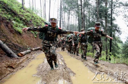 两名女兵手牵手经过湿滑路段 两名女兵手牵手经过湿滑路段