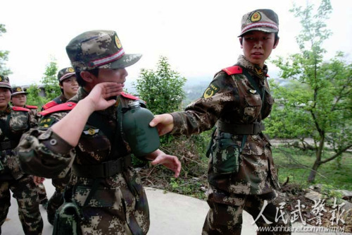 女兵李梦醒把水壶递向正在擦汗的战友吴映榆 女兵李梦醒把水壶递向正在擦汗的战友吴映榆