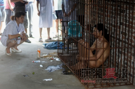 7月4日,邵东县水东江镇石牛村,医护人员正在看望关在特制铁笼里的曾军(化名)。图/记者华剑 7月4日,邵东县水东江镇石牛村,医护人员正在看望关在特制铁笼里的曾军(化名)。图/记者华剑