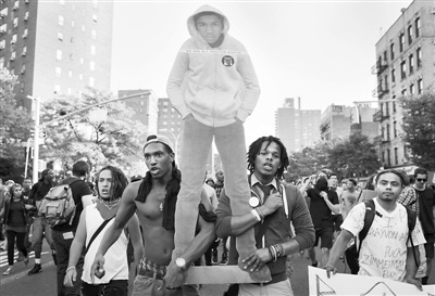 当地时间14日,纽约曼哈顿,示威者举着马丁的画像。 当地时间14日,纽约曼哈顿,示威者举着马丁的画像。