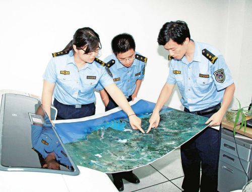 海监技术人员正在研究新绘制出的东海海域海岛地图 海监技术人员正在研究新绘制出的东海海域海岛地图