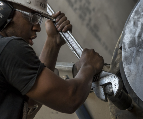 纽波特纽斯造船公司既代表了美国制造的强大,也有难以摆脱的困境。图为船厂工人在为福特号航母安装螺旋桨推进器。 纽波特纽斯造船公司既代表了美国制造的强大,也有难以摆脱的困境。图为船厂工人在为福特号航母安装螺旋桨推进器。