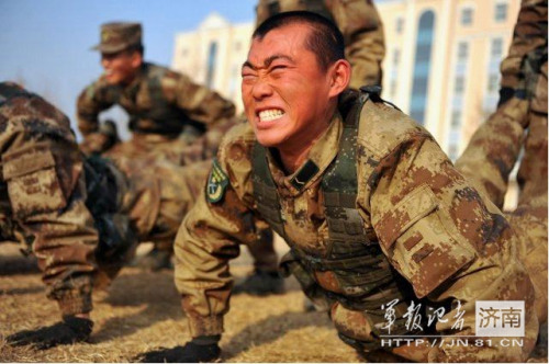 54军某师训练武装匍匐过障碍咬牙做俯卧撑图