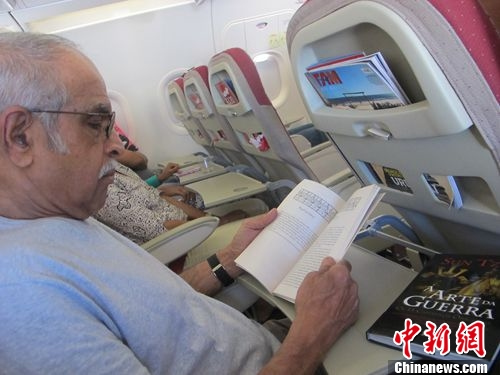 图为一位巴西老人在飞机上读《孙子兵法》 韩胜宝摄 图为一位巴西老人在飞机上读《孙子兵法》 韩胜宝摄