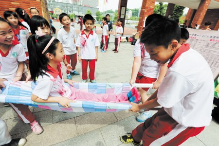 岳麓一小的学生学习用床单制作简易担架,以便险境互助。董渝生 摄 岳麓一小的学生学习用床单制作简易担架,以便险境互助。董渝生 摄