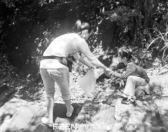 母亲带幼女一路捡登鼓山者丢弃的垃圾。网友供图 母亲带幼女一路捡登鼓山者丢弃的垃圾。网友供图