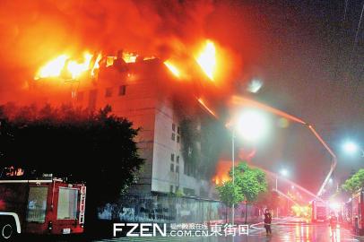 消防员在厂房外灭火。 消防员在厂房外灭火。