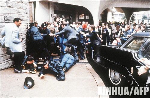 这是1981年3月30日,精神病患者约翰·欣克利在华盛顿试图行刺里根总统时,警察和特工人员迅速反应的资料照片。新华社/法新 这是1981年3月30日,精神病患者约翰·欣克利在华盛顿试图行刺里根总统时,警察和特工人员迅速反应的资料照片。新华社/法新