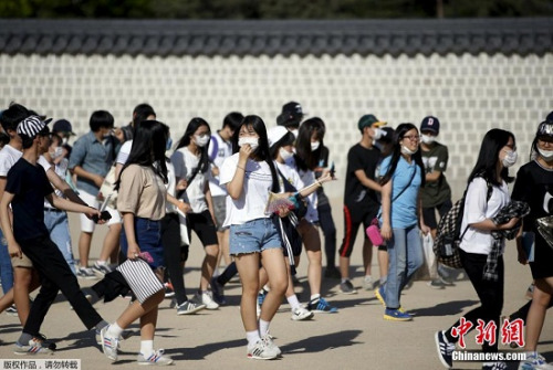 6月3日,在韩国首尔市中心的商业区,游客戴口罩出行。 6月3日,在韩国首尔市中心的商业区,游客戴口罩出行。