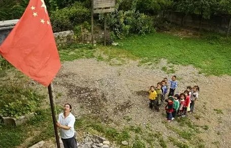 资料图:一位乡村教师正在升国旗。 资料图:一位乡村教师正在升国旗。