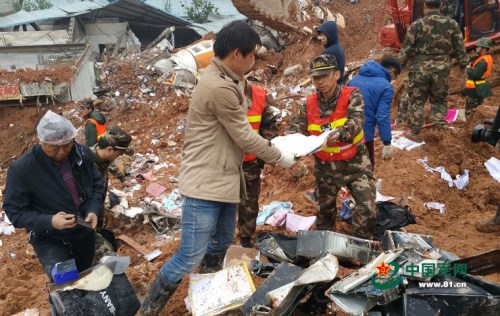 武警交通部队救援官兵将开挖抢救出来的物资移交给物主。 涂敦法 摄