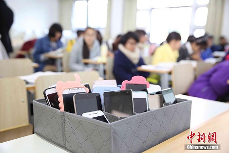 资料图：2014年11月20日，浙江农林大学动物科学专业14级的学生在教室里进行课间休息，他们的手机统一关机并放置在学生会提供的手机框里。 <a target='_blank' href='http://www.chinanews.com/'>中新社</a>发 陈胜伟 摄 图片来源：CNSPHOTO