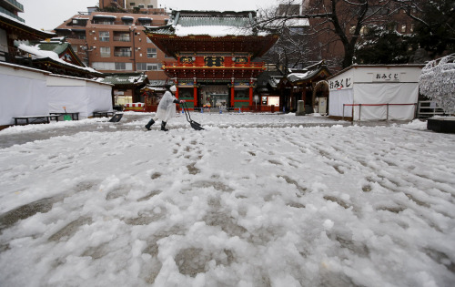 一名男子清理神社前的积雪。 一名男子清理神社前的积雪。