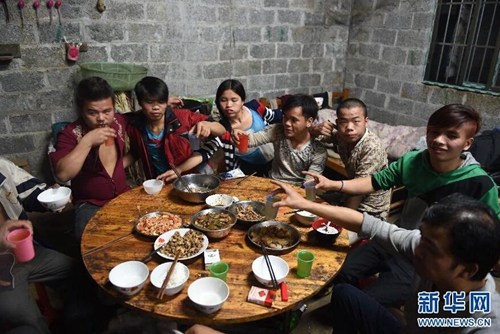 2015年2月18日,在弄勇村弄顶屯,年轻人聚在一起吃年夜饭。图片来源:新华网 2015年2月18日,在弄勇村弄顶屯,年轻人聚在一起吃年夜饭。图片来源:新华网