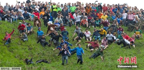 英国格罗斯特郡布洛克维尔夫,一年一度的滚乳酪大赛(Cheese Rolling)。参赛选手在比赛中追赶一个从陡坡上滚下的巨大奶酪轮,“奶酪勇士”们就算被摔断胳膊和腿也在所不惜。 英国格罗斯特郡布洛克维尔夫,一年一度的滚乳酪大赛(Cheese Rolling)。参赛选手在比赛中追赶一个从陡坡上滚下的巨大奶酪轮,“奶酪勇士”们就算被摔断胳膊和腿也在所不惜。
