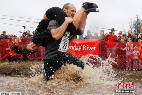 美国缅因州,当地举办“北美背媳妇大赛”,参与者越过重重障碍奋力前行。 美国缅因州,当地举办“北美背媳妇大赛”,参与者越过重重障碍奋力前行。