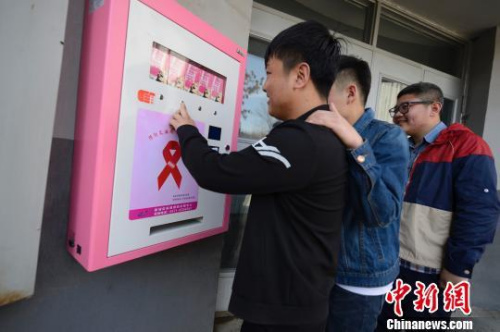 资料图:内蒙古工业大学学生对安全套自助发放机充满好奇,三五成群聚在发放机面前。 刘文华 摄 资料图:内蒙古工业大学学生对安全套自助发放机充满好奇,三五成群聚在发放机面前。 刘文华 摄