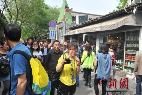 图为一位导游带游客参观南锣鼓巷。吕春荣 摄 图为一位导游带游客参观南锣鼓巷。吕春荣 摄