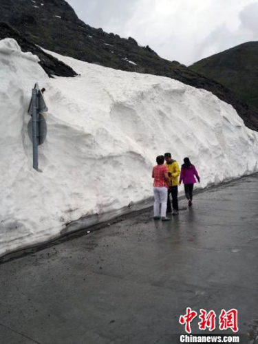 天山公路新源至唐布拉段,车辆行进至玉希莫勒盖隧道时,公路旁的雪墙高达4米,吸引旅客驻足拍照。 王小军 摄 天山公路新源至唐布拉段,车辆行进至玉希莫勒盖隧道时,公路旁的雪墙高达4米,吸引旅客驻足拍照。 王小军 摄