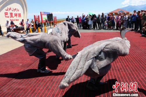 图为几位反穿羊皮大衣的表演者在巴里坤湖景区模拟大雁表演《大雁舞》。 耿丹丹 摄 图为几位反穿羊皮大衣的表演者在巴里坤湖景区模拟大雁表演《大雁舞》。 耿丹丹 摄