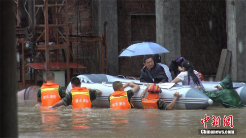 7月1日,湖北广水市平岭镇朝阳街因暴雨发生严重内涝,致大量居民被困。广水市消防官兵携皮划艇、救生衣、安全绳等赴现场救援。在现场,救援人员发现,汹涌的洪水正四处肆虐,整条街道已被一米多深的积水淹没,不少居民在自家二楼处等待救援。于是,消防官兵挨家挨户对被困人员进行搜救转移。截至15时20分,救援人员历时三小时,成功将100余名被困人员转移至安全地带。图为几名消防官兵合力推动皮划艇前行。 李航 摄 7月1日,湖北广水市平岭镇朝阳街因暴雨发生严重内涝,致大量居民被困。广水市消防官兵携皮划艇、救生衣、安全绳等赴现场救援。在现场,救援人员发现,汹涌的洪水正四处肆虐,整条街道已被一米多深的积水淹没,不少居民在自家二楼处等待救援。于是,消防官兵挨家挨户对被困人员进行搜救转移。截至15时20分,救援人员历时三小时,成功将100余名被困人员转移至安全地带。图为几名消防官兵合力推动皮划艇前行。 李航 摄