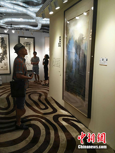 7月7日，北京银座2016春季拍卖会预展在京举行。张大千的作品《松峰晓霭图》为本次拍卖会标的最高的一件拍品。图为预展现场，观众在欣赏《松峰晓霭图》。宋宇晟 摄