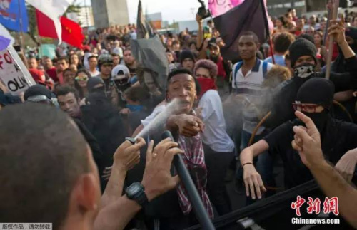 当地时间8月2日,巴西尼泰罗伊,里约奥运会火炬传递行进途中,示威者闹场与警方激烈冲突,抗议里约奥运会花费。图为警察向示威者喷胡椒喷雾。 当地时间8月2日,巴西尼泰罗伊,里约奥运会火炬传递行进途中,示威者闹场与警方激烈冲突,抗议里约奥运会花费。图为警察向示威者喷胡椒喷雾。