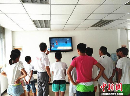 王志英以及徐州田径队的小队员们聚在电视前观看比赛。 朱志庚 摄 王志英以及徐州田径队的小队员们聚在电视前观看比赛。 朱志庚 摄