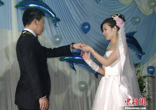 图为婚礼上,杜丽为庞伟戴上戒指。<a target='_blank' href='http://www.chinanews.com/'>中新社</a>发 吕子豪 摄 图为婚礼上,杜丽为庞伟戴上戒指。<a target='_blank' href='http://www.chinanews.com/'>中新社</a>发 吕子豪 摄