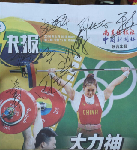 中国举重队的多位选手和教练在《奥运快报》上签名。(图片来源:南美侨报网) 中国举重队的多位选手和教练在《奥运快报》上签名。(图片来源:南美侨报网)