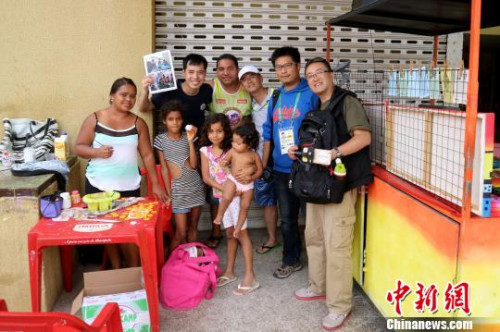 生活在里约阿莱芒贫民窟的画摊老板克莱伯一家与<a target='_blank' href='http://www.chinanews.com/' >中新网</a>记者合影。摄于2016年8月16日。 余瑞冬 摄 生活在里约阿莱芒贫民窟的画摊老板克莱伯一家与<a target='_blank' href='http://www.chinanews.com/' >中新网</a>记者合影。摄于2016年8月16日。 余瑞冬 摄