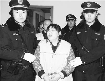 图为二审开庭时,法警押解张伟兰进入法庭。 丁力辛 摄 图为二审开庭时,法警押解张伟兰进入法庭。 丁力辛 摄