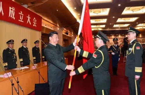 近平向武汉联勤保障基地司令员李士生、政治委员殷志红授军旗。