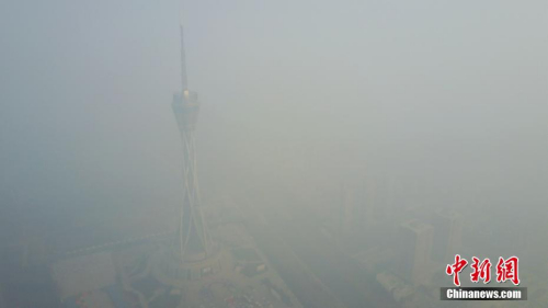 连日以来河南郑州被雾霾笼罩，12月18日，河南郑州仍是雾霾围城，图为隐身于雾霾之中的河南广播电视发射塔。王中举 摄