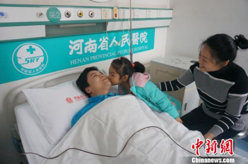 在朱冠军捐献造血干细胞的过程中,妻子女儿全程陪伴,女儿贴心地亲吻他给他加油打气。 韩章云 摄 在朱冠军捐献造血干细胞的过程中,妻子女儿全程陪伴,女儿贴心地亲吻他给他加油打气。 韩章云 摄