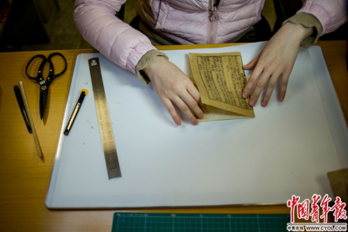 2016年12月20日,国图的古籍修复室内,潘菲正在对古籍中的一页进行修复工作。中国青年报·中青在线记者 李隽辉/摄 2016年12月20日,国图的古籍修复室内,潘菲正在对古籍中的一页进行修复工作。中国青年报·中青在线记者 李隽辉/摄