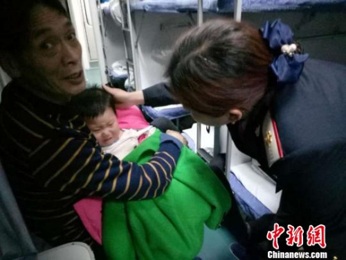 图为列车乘务员正在处置列车上的患病儿童。 王玉 摄 图为列车乘务员正在处置列车上的患病儿童。 王玉 摄