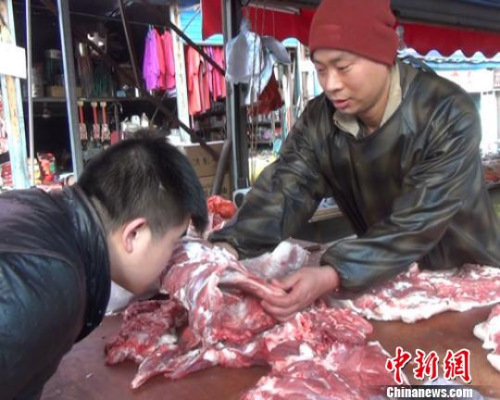 资料图:一位卖羊肉的摊贩正在教顾客从肉质、色泽、气味等方面识别瘦肉精羊肉 阚力 摄 资料图:一位卖羊肉的摊贩正在教顾客从肉质、色泽、气味等方面识别瘦肉精羊肉 阚力 摄